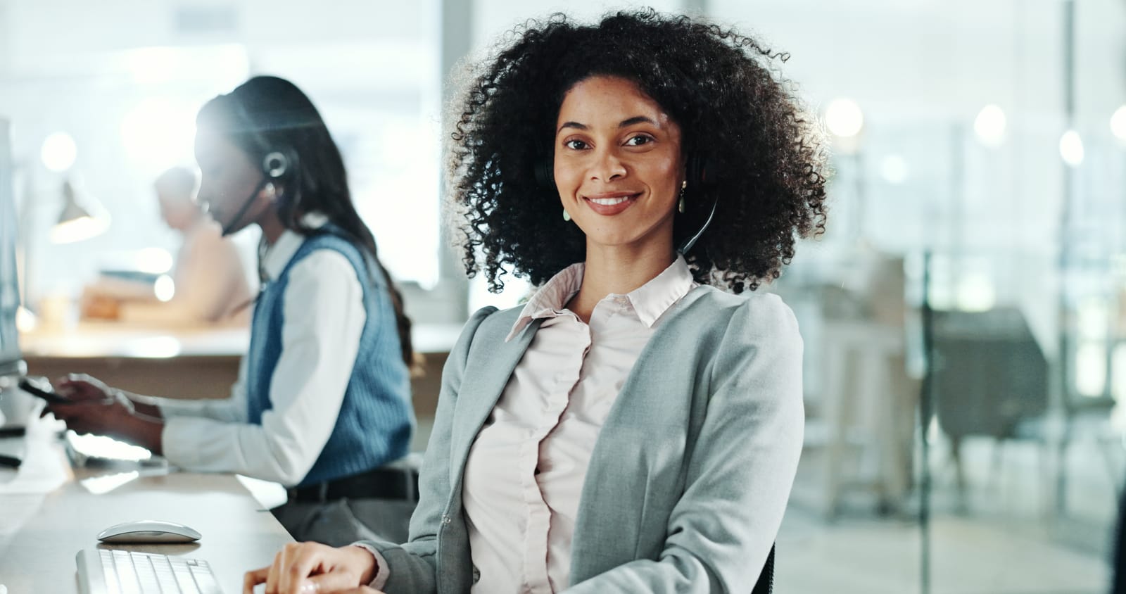 Smiling agent wearing a headset in a modern office