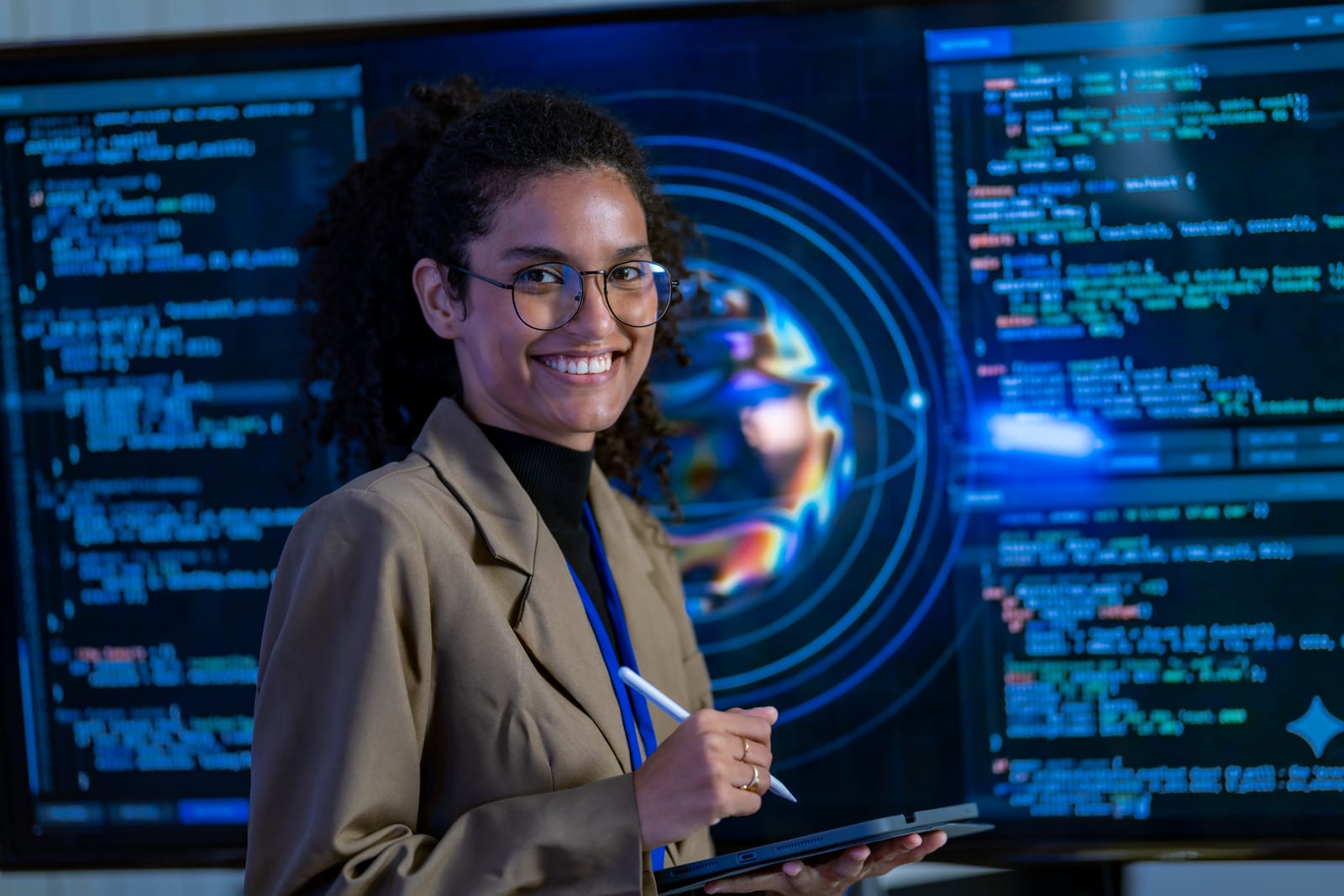 Marketer with a tablet in front of large screens showing code and a glowing globe